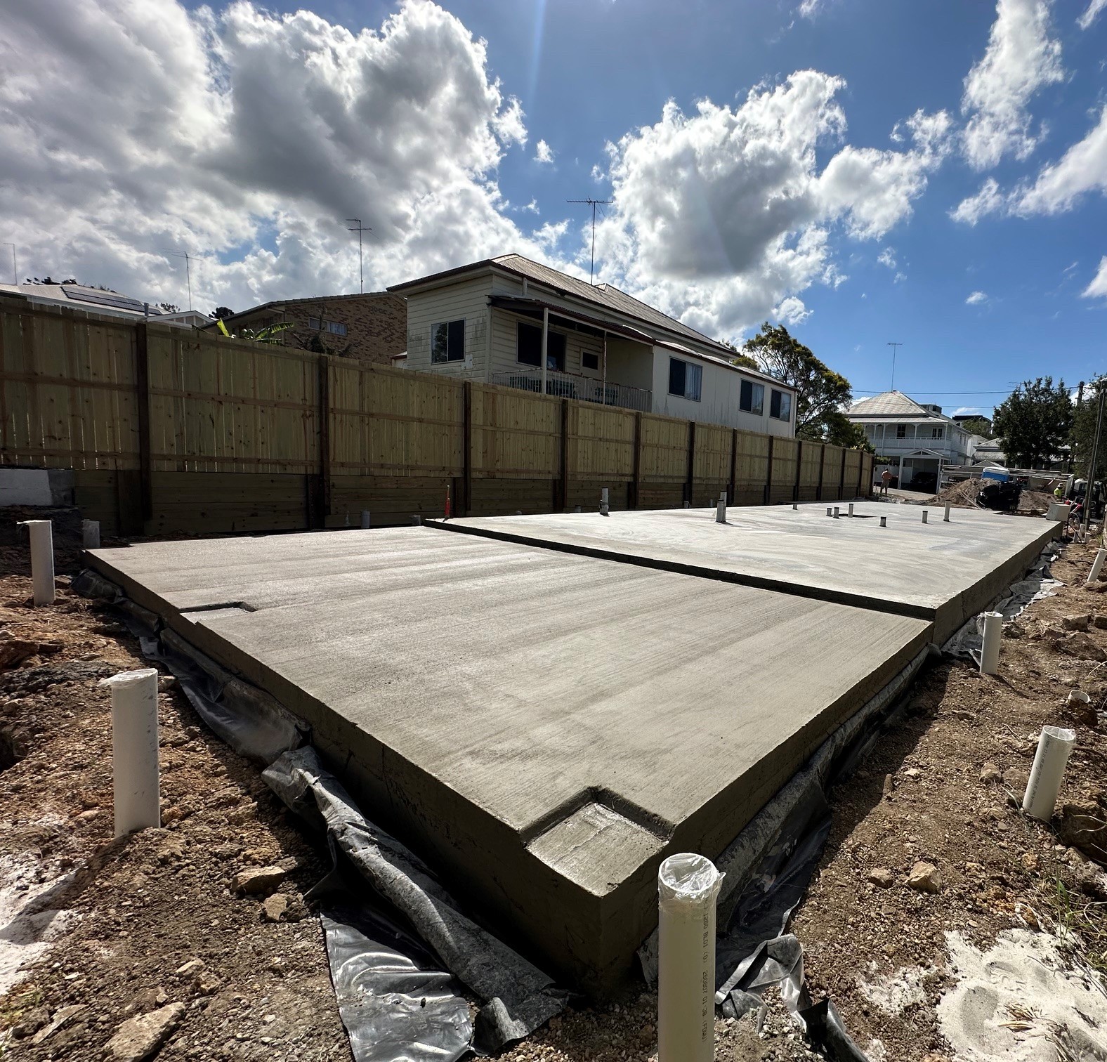 The completed concrete slab at the Annie St custom home build in Brisbane, photographed on site under a bright blue sky